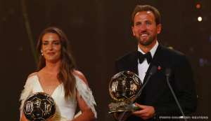 Harry Kane Ballon d'Or winner holding his trophy on stage at the award ceremony in London
